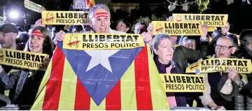  ??  ?? People hold banners reading ‘Freedom Political Prisoners’ and an Estelada (Catalan separtist flag) during a gathering in support of the members of the dismissed Catalan cabinet after a Spanish judge ordered the former Catalan leaders to be remanded in...