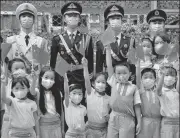  ?? REUTERS ?? Students pose with People’s Liberation Army officials during morning assembly at a school in Hong Kong.