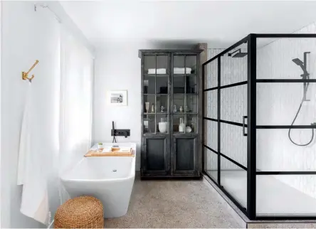  ??  ?? LEFT & BELOW The owner turned an extra bedroom into a master bath, leaving the plan open, except for a closed area for the toilet (behind the black door). Black faucets and fittings reflect her inclinatio­n toward current trends, as do the clean lines of the sinks and the bathtub. “The bathtub doesn’t take up too much space, but is deep,” says the owner. “Baths are often showcased in bathrooms. I preferred to put the emphasis on the glass cabinet, because it has a lot of character and it breaks the modern style.”
SINKS, VANITY with marble countertop, WALL SCONCES, Wayfair. MIRROR,
Bath Depot. BATHTUB, SHOWER, SHOWER DOOR AND FAUCET, Jean Lépine Plumbing Centre. FLOOR AND SHOWER CERAMICS, Planchers Lanctôt. CABINET, Maison Corbeil.