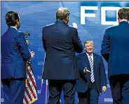  ?? AP/SUSAN WALSH ?? President Donald Trump is greeted Friday by his son Donald Trump Jr. (left) and National Rifle Associatio­n president Wayne LaPierre (second from left) as he walks on stage in Dallas.