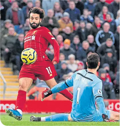  ??  ?? Mo Salah beats Southampto­n keeper Alex McCarthy to keep the Liverpool bandwagon title-bound