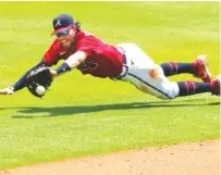  ?? AP PHOTO/CURTIS COMPTON ?? Atlanta Braves shortstop Dansby Swanson makes a diving catch against the visiting New York Mets on Sunday at Truist Park.