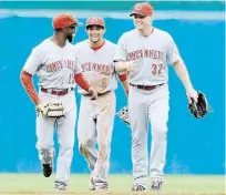  ??  ?? DE IZQUIERDA a derecha, Derrick Robinson, Billy Hamilton y Jay Bruce celebran luego de que los Rojos vencieran a Pittsburgh.