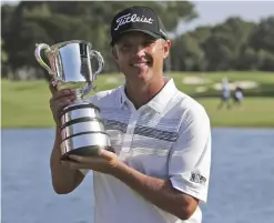  ??  ?? SYDNEY: Matthew Jones of Australia poses for photograph­ers as he holds the Stone Haven Cup after winning the Australian Open golf tournament in Sydney yesterday. — AP