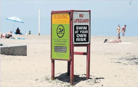  ?? BOB TYMCZYSZYN THE ST. CATHARINES STANDARD ?? Swim at your own risk signs are up with water quality postings at Lakeside Park in Port Dalhousie. Temperatur­es hit 32 C Monday.