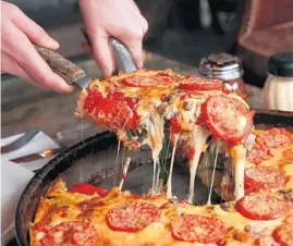  ?? CHICAGO TRIBUNE 2014 ?? The Lou is a pizza topped with spinach mix, mushrooms, sliced Roma tomatoes and a three cheese blend at Lou Malnati’s pizzeria in Chicago.