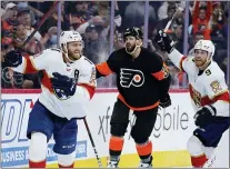  ?? MATT SLOCUM — THE ASSOCIATED PRESS ?? Florida’s Jonathan Huberdeau, left, and Sam Bennett, right, celebrate past the Flyers’ Keith Yandle after Huberdeau’s g0-ahead goal during the third period.