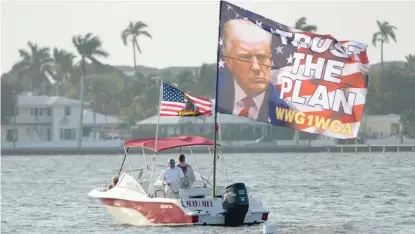  ?? LYNNE SLADKY/AP ?? Supporters of former President Donald Trump fly a flag from a boat on Saturday outside of Trump's Mar-a-Lago estate.