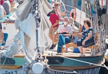  ?? BRAD HORRIGAN PHOTOS/HARTFORD COURANT ?? Passengers await the start of a cruise on board the Argia in Mystic. With so many summer travel plans upended by the coronaviru­s pandemic, the Connecticu­t shoreline has seen a surprising number of visitors from northeaste­rn states.