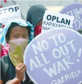  ?? AP FOTO ?? RALLY. Protesters display placards during a rally outside Camp Aguinaldo to protest the allout war being waged by the military and police against communist rebels following the recent collapse of the peace talks. Both sides have suffered casualties...