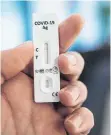  ?? FOTO: DPA ?? Ein Mann hält einen negativen Coronaschn­elltest in der Hand: Unternehme­n müssen bald Tests anbieten.