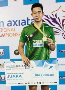  ??  ?? A happy man: Penang’s Yeoh Seng Zoe posing with the gold medal and mock cheque after winning the men’s singles final of the National Under-21 tournament in Penang yesterday.