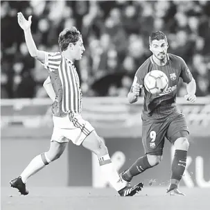 ?? — Gambar Reuters ?? AKSI MEMUKAU: Suarez (kanan) bersaing dengan pemain Real Sociedad, Alvaro Odriozola untuk mendapatka­n bola pada perlawanan La Liga Sepanyol di Stadium Anoeta, San Sebastian pada Ahad lepas.
