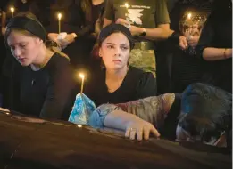  ?? EFREM LUKATSKY/AP ?? Relatives mourn Monday in a Kyiv cathedral during a funeral for a Ukrainian soldier codenamed Fanat who died in combat against Russian forces.