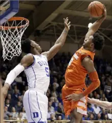  ?? The Associated Press ?? Syracuse’s Elijah Hughes dunks on RJ Barrett in a 95-91 upset of top-ranked Duke Monday at Cameron Indoor.
