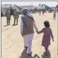  ?? DAVID GOLDMAN — THE ASSOCIATED PRESS ?? A man walks with a child through Fort Bliss’ Doña Ana Village on Friday.