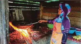  ??  ?? MARIAM menggoreng pisang di atas dapur kayu di gerainya.