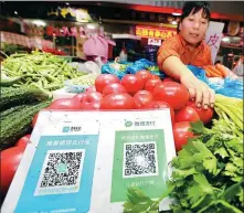  ?? XU CONGJUN / FOR CHINA DAILY ?? Customers can pay via Alipay and WeChat at a vegetable market in Nantong, Jiangsu province.