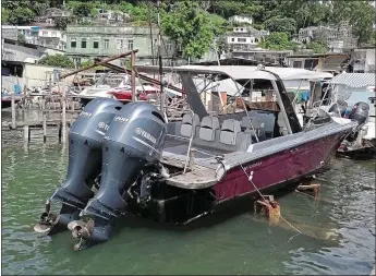  ??  ?? PERILOUS FLIGHT: Andy Li, right, tried to escape across the South China Sea with 11 others in this tiny boat, but was intercepte­d by coastguard­s