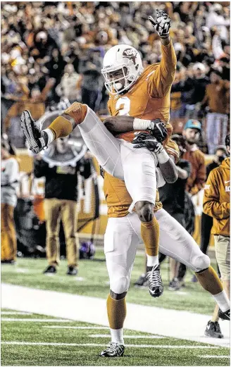  ?? RODOLFO GONZALEZ / AUSTIN AMERICAN-STATESMAN ?? Texas wide receiver Armanti Foreman (3) is hoisted by his brother, running back D’Onta Foreman, after Armanti’s second-half touchdown in Saturday’s rout of Kansas.