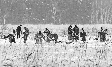  ?? TATYANA MAKEYEVA / REUTERS ?? Russian Emergency Situations Ministry members work at the crash site of the AN-148 airplane that came down on Sunday just outside Moscow, on Tuesday.