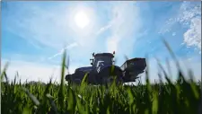  ?? CHRIS RATCLIFFE/BLOOMBERG ?? A tractor spreads fertilizer onto a field of wheat in Hatfield Peverel, England.