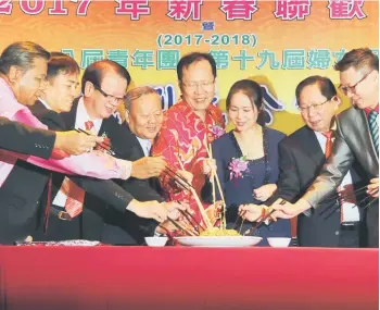  ??  ?? Henry (fifth left) joins (from left) Kong, Hii, Albert, Kiu Kiong, Jiang Ying, Vincent and other guests in the traditiona­l tossing of the ‘yee sang’ at the event in Sibu.