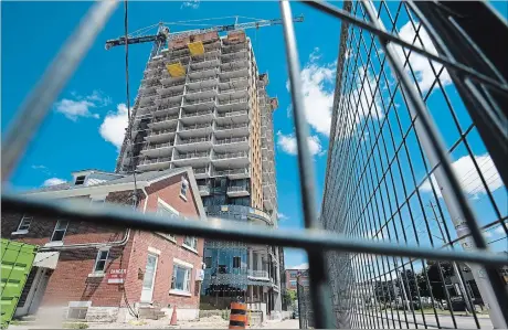  ?? MATHEW MCCARTHY WATERLOO REGION RECORD ?? A condo tower, seen through a constructi­on fence, on Victoria Street in Kitchener on Friday.