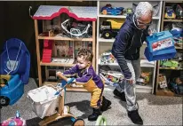  ?? RICHARD TSONG-TAATARII / MINNEAPOLI­S STAR TRIBUNE / TNS ?? Ceola McClure-Lazo helps grandson Vail, 21 months, test out toys at the Toy Library.