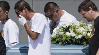  ?? HANS GUTKNECHT /THE ORANGE COUNTY REGISTER VIA AP ?? In this July 20, file photo Victor Avalos, the father of Anthony Avalos, (second from left), carries his son’s casket out of the Saint Junipero Serra Parish church in Lancaster, Calif., after the funeral service of his son.