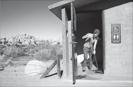  ?? [MARIO TAMA/GETTY IMAGES] ?? Volunteer Alexandra Degen cleans a restroom at Joshua Tree National Park in southern California east of Los Angeles on Friday. Volunteers have pitched in because the partial federal government shutdown has left the park understaff­ed.