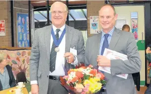  ?? Mark Giller ?? ●● Rainow Parish Council vice chairman Alan Brett presented former Rainow Primary School headteache­r Mark Bertinshaw with flowers at the civic service honouring people in the village