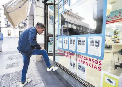  ?? MANUEL MURILLO ?? Un joven observa los anuncios publicados en el escaparate de una inmobiliar­ia.