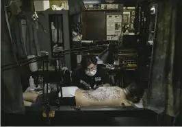  ?? HARUKA SAKAGUCHI — THE NEW YORK TIMES ?? Asami, a tattoo artist, works on a client at his studio in Yokosuka, Japan, this month. He said that people with tattoos needed “to be extra well-mannered and follow the rules.”