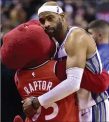  ?? FRANK GUNN, THE CANADIAN PRESS ?? Sacramento Kings guard Vince Carter is embraced by The Raptor, in what is possibly his last game in Toronto.