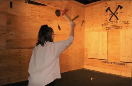  ?? PHOTOS BY MICHILEA PATTERSON — FOR MEDIANEWS GROUP ?? Marisa Sholl, of Exeter, uses a one-handed technique to throw an axe as part of a special yoga event that was held at the Splitting Edge Axe Throwing in downtown Pottstown.