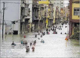  ?? Ramon Espinosa ?? The Associated Press People move Sunday through flooded streets in Havana after the passage of Hurricane Irma. Cuban officials warned residents to watch for even more flooding over the next few days.