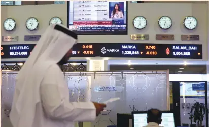  ?? (Reuters) ?? TRADERS MONITOR stock informatio­n at the Dubai Financial Market in the United Arab Emirates on Monday. The head of Middle Eastern debt capital markets at a European bank in Dubai said his institutio­n has put all new Qatari business on hold while it...