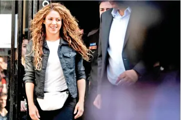  ?? — AFP photos ?? Shakira leaves a court in Madrid on Wednesday. (Below) Journalist­s attempt to speak with Shakira as she leaves the court.