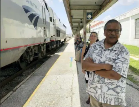  ?? AP PHOTO/MIKE SCHNEIDER ?? Jishnu Mukdrji and Penny Jacobs wait to board an Amtrak train in Orlando, Fla. Murkdrji and Jacobs became friends from online train forums that get other rail enthusiast­s together for trips around the United States. They were headed to Pennsylvan­ia for a memorial service for one of the members in their train group who died of a heart attack in July while traveling with his train buddies to New Orleans.