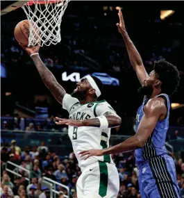  ?? MIKE WATTERS/USA TODAY SPORTS ?? Bucks forward Bobby Portis goes to the basket in front of Magic forward Jonathan Isaac during the second quarter Sunday at KIA Center in Orlando, Fla.
