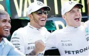  ??  ?? Mercedes driver Lewis Hamilton of Britain, center, celebrates with Mercedes driver Valtteri Bottas of Finland after winning the Italian Formula One Grand Prix at the Monza racetrack in Italy Sunday. (AP)