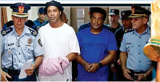  ??  ?? A gloomy Ronaldinho and his elder brother Assis in handcuffs before spending 32 days in a Paraguayan prison