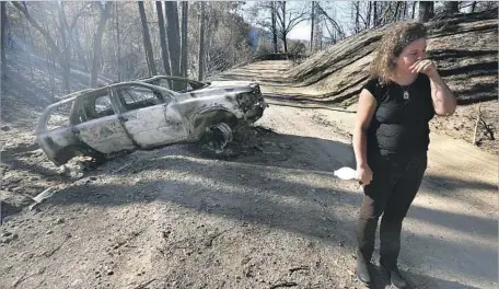  ?? Genaro Molina Los Angeles Times ?? CHARLOTTE SCOTT of Redwood Valley stands near her charred car Oct. 18. Nine people in Redwood Valley died in the fire last month.