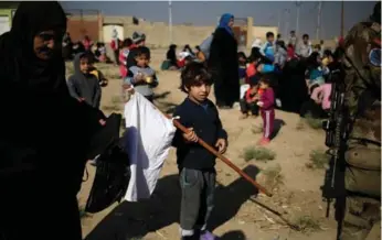  ?? ZOHRA BENSEMRA/REUTERS ?? A boy in eastern Mosul emerges from his house with a white flag after Iraqi forces drive out Daesh fighters.