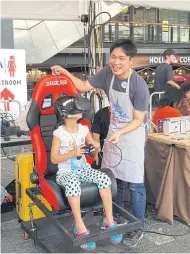  ??  ?? A child tries the VR programme created by the Ayarafun team.