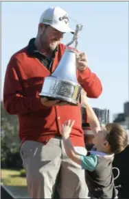 ?? PHELAN M. EBENHACK — THE ASSOCIATED PRESS ?? Marc Leishman, of Australia, holds the championsh­ip trophy as his son Oliver, 3, jumps up to slap it after Leishman won the Arnold Palmer Invitation­al golf tournament in Orlando, Fla., Sunday.