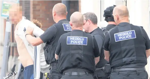  ?? Richard Williams ?? > A man is taken away by police after the incident in Lower Cathedral Road, Cardiff, yesterday