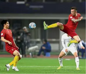  ??  ?? Stretch: Wang Yongpo (right) of China kicking the ball to his teammate during the World Cup qualifier against South Korea in Changsha on Thursday.
