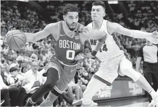  ?? LYNNE SLADKY AP ?? Boston Celtics forward Jayson Tatum (left) drives past Heat guard Tyler Herro during the first half of Thursday’s Game 2 of the Eastern Conference finals, won by the Celtics.